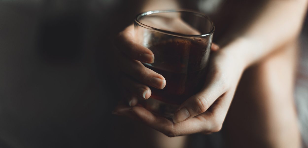 woman's hand with alcohol drink in glass with copy space