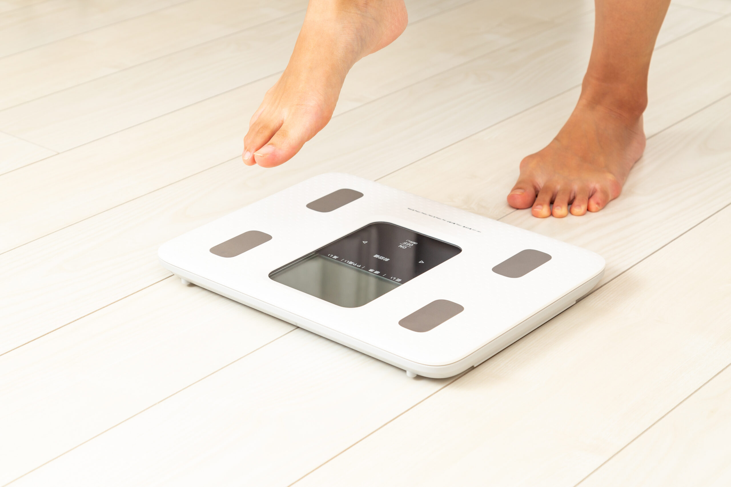 体重計にのる女性の足