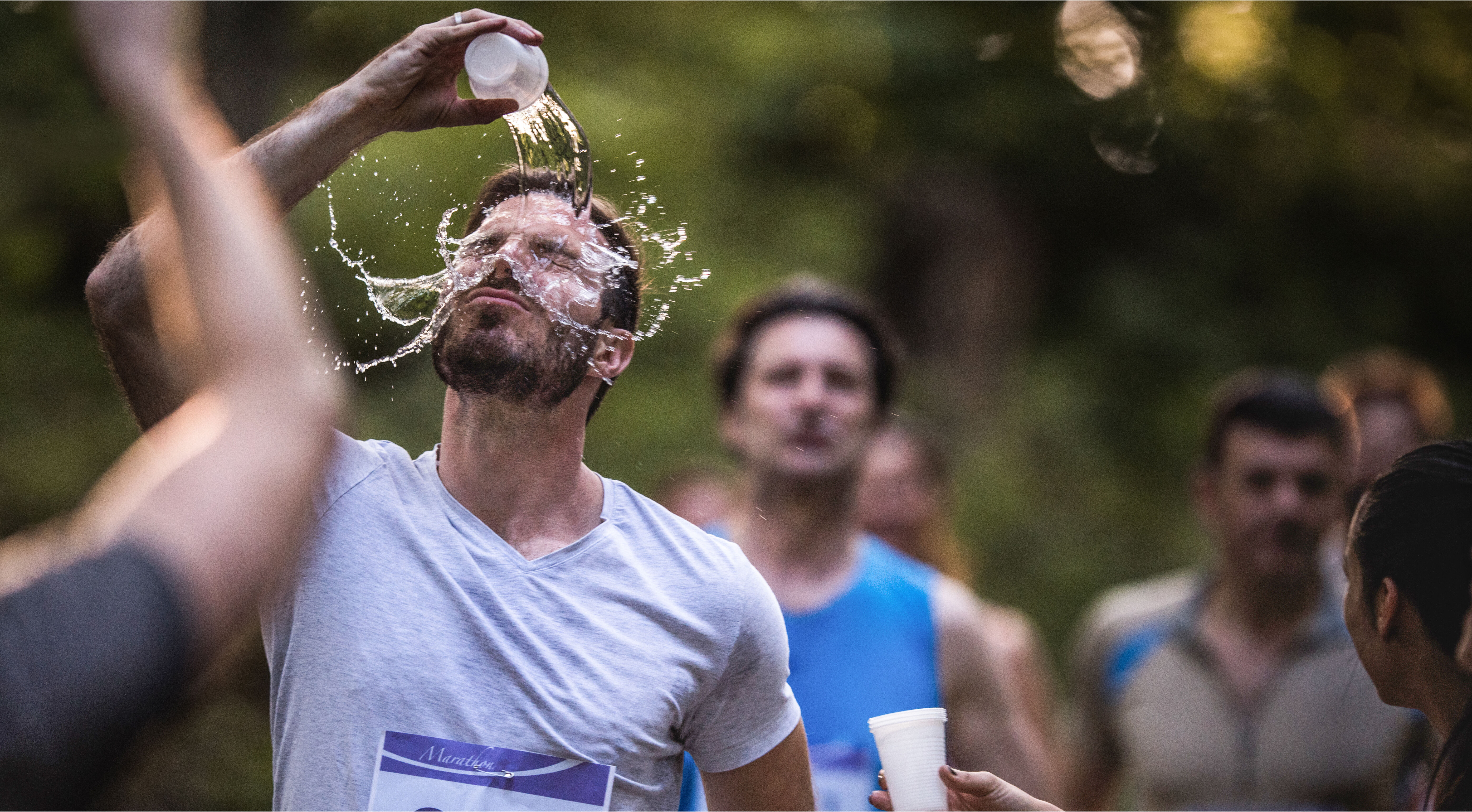 Marathonläufer erfrischt sich mit Wasser