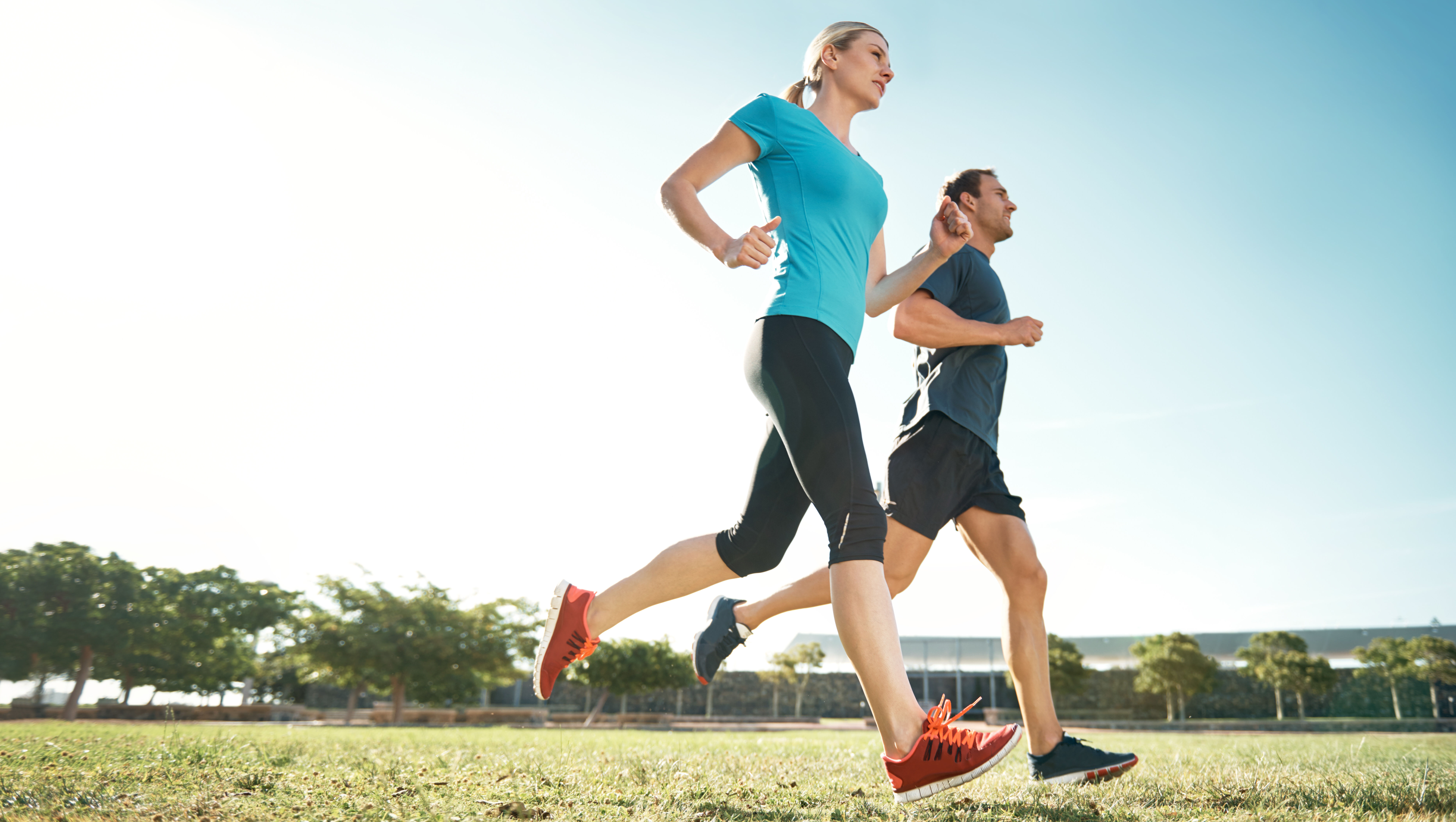 Eine Frau und ein Mann laufen auf einem Feldweg